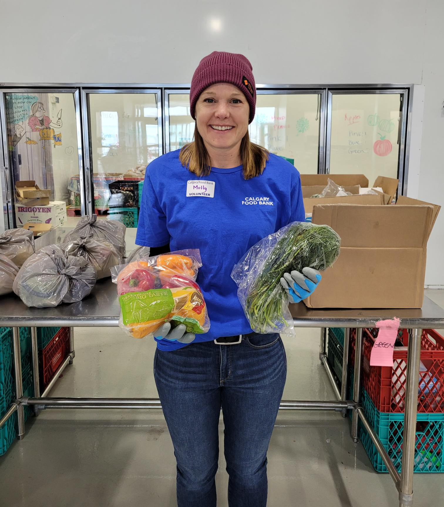 Volunteer holding fresh produce in the Calgary Food Bank warehouse